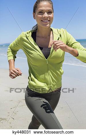 Smiling woman running on the beach View Large Photo Image Stock Image - Smiling woman running on the beach. Fotosearch