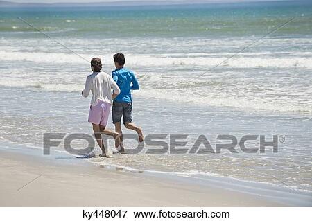 Stock Photo - Two men running on the beach. Fotosearch