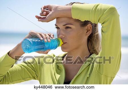 Woman drinking water from a bottle View Large Photo Image Stock Photograph - Woman drinking water from a bottle. Fotosearch