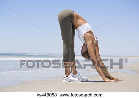 Stock Photo - Woman exercising on the beach. Fotosearch