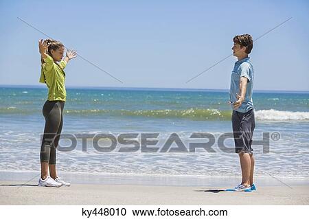 Woman exercising on the beach with her coach View Large Photo Image Stock Image - Woman exercising on the beach with her coach. Fotosearch