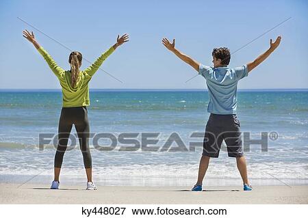 Woman exercising on the beach with her coach View Large Photo Image Stock Photo - Woman exercising on the beach with her coach. Fotosearch