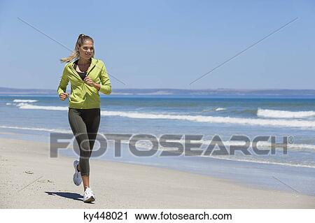 Woman jogging on the beach View Large Photo Image Stock Image - Woman jogging on the beach. Fotosearch