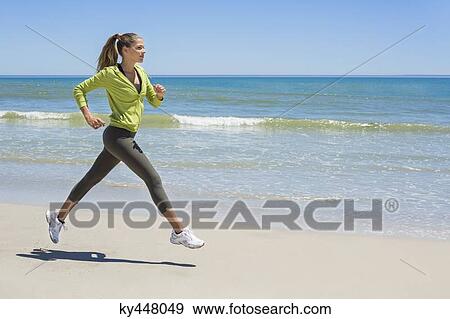 Stock Photo - Woman jogging on the beach. Fotosearch
