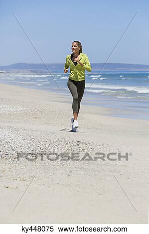Stock Photography - Woman jogging on the beach. Fotosearch