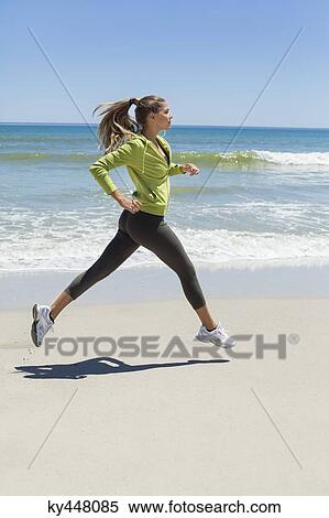 Stock Photography - Woman jogging on the beach. Fotosearch
