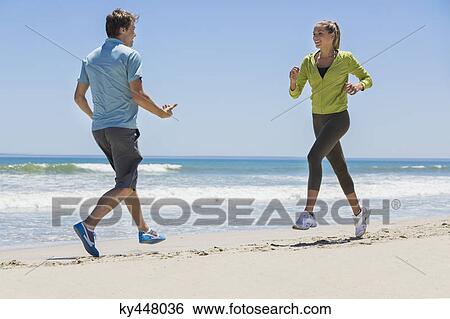 Woman jogging on the beach with her coach View Large Photo Image Stock Photograph - Woman jogging on the beach with her coach. Fotosearch