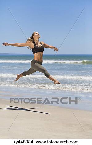 Woman jumping on the beach View Large Photo Image Picture - Woman jumping on the beach. Fotosearch