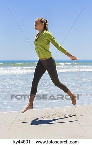 Woman jumping rope on the beach View Large Photo Image Stock Image - Woman jumping rope on the beach. Fotosearch