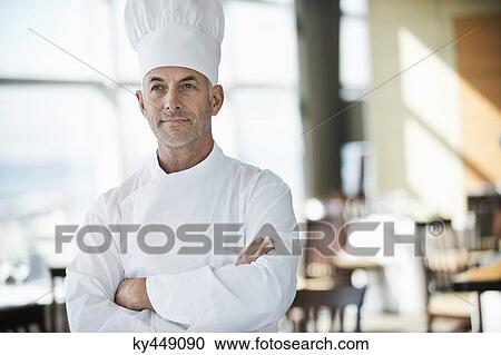 Chef standing with arms crossed in a restaurant View Large Photo Image Stock Image - Chef standing with arms crossed in a restaurant. Fotosearch
