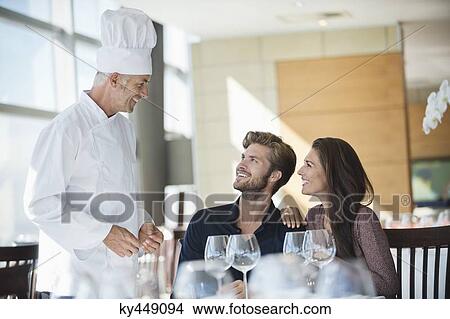 Chef talking to couple at restaurant View Large Photo Image Picture - Chef talking to couple at restaurant. Fotosearch