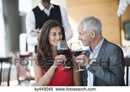 Couple enjoying red wine in a restaurant View Large Photo Image Stock Photography - Couple enjoying red wine in a restaurant. Fotosearch