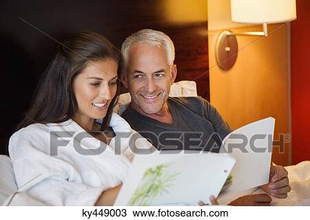 Couple reading a book in a hotel room View Large Photo Image Stock Image - Couple reading a book in a hotel room. Fotosearch
