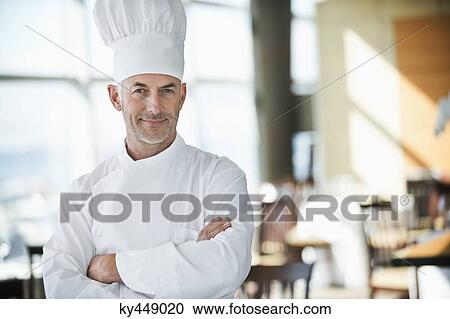 Portrait of a chef smiling with arms crossed in a restaurant View Large Photo Image Stock Image - Portrait of a chef smiling with arms crossed in a restaurant. Fotosearch