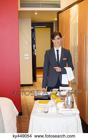 Portrait of waitress smiling with room service table in a hotel room View Large Photo Image Picture - Portrait of waitress smiling with room service table in a hotel room. Fotosearch