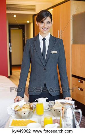 Portrait of waitress smiling with room service table in a hotel room View Large Photo Image Stock Image - Portrait of waitress smiling with room service table in a hotel room. Fotosearch