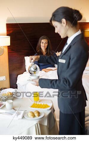 Waitress serving tea to a woman in a hotel room View Large Photo Image Stock Photo - Waitress serving tea to a woman in a hotel room. Fotosearch