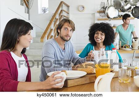 Stock Image - Friends at a dining table. Fotosearch