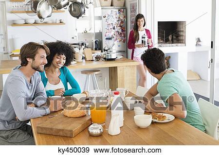 Friends at a dining table View Large Photo Image Stock Photo - Friends at a dining table. Fotosearch