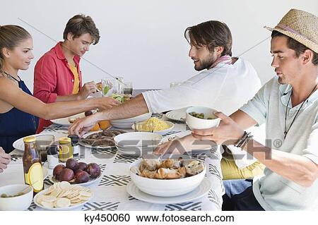 Friends eating lunch at dining table View Large Photo Image Stock Image - Friends eating lunch at dining table. Fotosearch