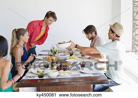 Friends eating lunch at dining table View Large Photo Image Stock Image - Friends eating lunch at dining table. Fotosearch