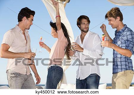 Friends enjoying drinks and dance in a party View Large Photo Image Stock Image - Friends enjoying drinks and dance in a party. Fotosearch