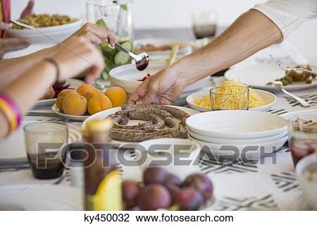 Friends having lunch at a dining table View Large Photo Image Stock Image - Friends having lunch at a dining table. Fotosearch