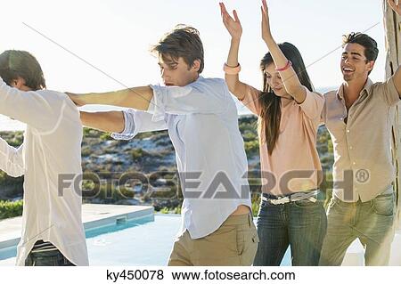 Group of friends dancing at the poolside View Large Photo Image Stock Photo - Group of friends dancing at the poolside. Fotosearch