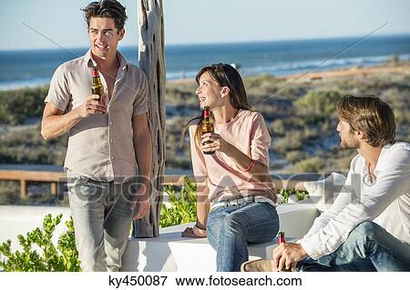 Group of friends enjoying beer outdoors on vacation View Large Photo Image Stock Photo - Group of friends enjoying beer outdoors on vacation. Fotosearch