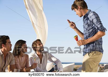 Stock Image - Group of friends enjoying drinks in party. Fotosearch