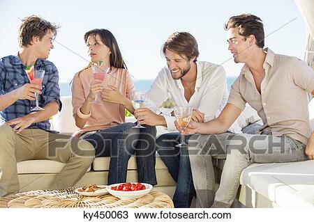 Group of friends enjoying drinks outdoors on vacation View Large Photo Image Stock Image - Group of friends enjoying drinks outdoors on vacation. Fotosearch