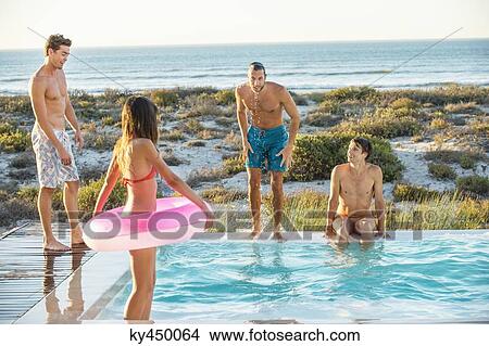 Group of friends enjoying in a swimming pool on the beach View Large Photo Image Picture - Group of friends enjoying in a swimming pool on the beach. Fotosearch