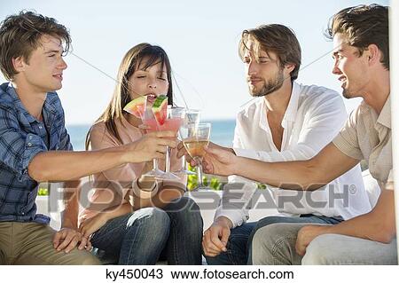 Group of friends toasting drinks outdoors on vacation View Large Photo Image Stock Image - Group of friends toasting drinks outdoors on vacation. Fotosearch