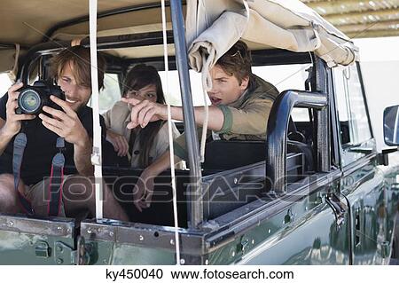 Man photographing with his friends in a SUV View Large Photo Image Stock Image - Man photographing with his friends in a SUV. Fotosearch