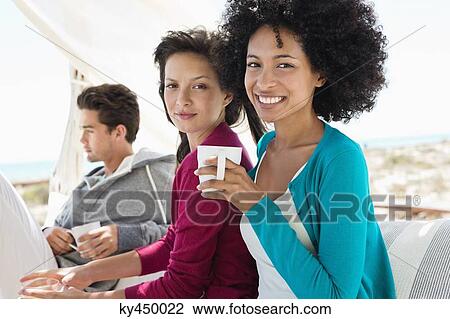 Portrait of two female friends enjoying coffee View Large Photo Image Stock Image - Portrait of two female friends enjoying coffee. Fotosearch