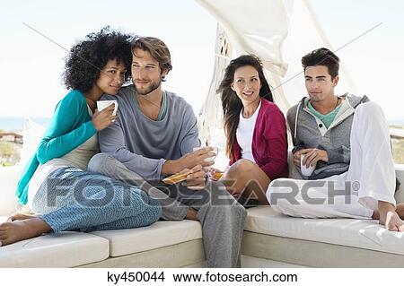 Smiling friends enjoying coffee on the terrace View Large Photo Image Picture - Smiling friends enjoying coffee on the terrace. Fotosearch