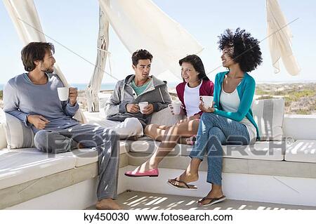 Smiling friends enjoying coffee on the terrace View Large Photo Image Stock Image - Smiling friends enjoying coffee on the terrace. Fotosearch