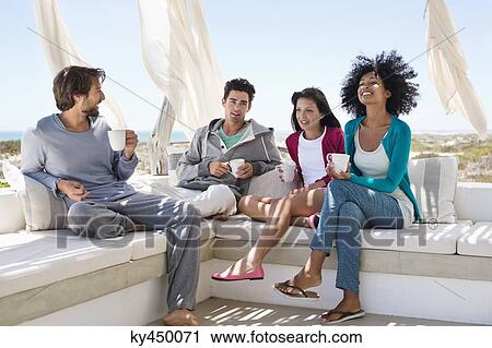 Smiling friends enjoying coffee on the terrace View Large Photo Image Stock Image - Smiling friends enjoying coffee on the terrace. Fotosearch