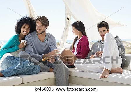 Smiling friends enjoying coffee on the terrace View Large Photo Image Stock Photography - Smiling friends enjoying coffee on the terrace. Fotosearch