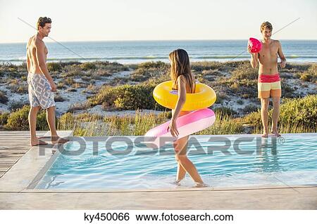 Three friends enjoying at a swimming pool on the beach View Large Photo Image Stock Photograph - Three friends enjoying at a swimming pool on the beach. Fotosearch