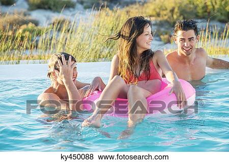 Three friends enjoying in a swimming pool on the beach View Large Photo Image Stock Photo - Three friends enjoying in a swimming pool on the beach. Fotosearch