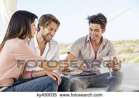 Three friends enjoying snacks and drinks in outdoor View Large Photo Image Stock Photography - Three friends enjoying snacks and drinks in outdoor. Fotosearch