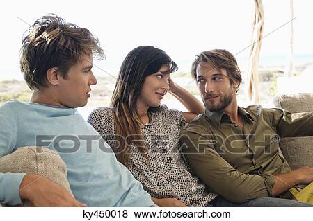 Stock Photo - Three friends sitting together on a couch. Fotosearch