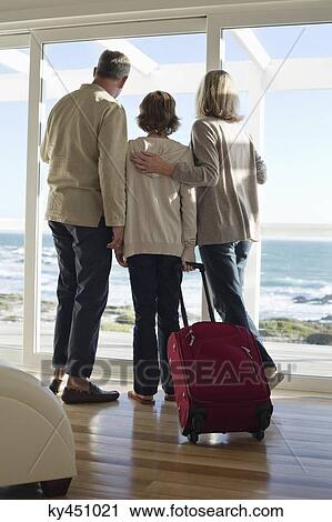 Boy looking through a window with his grandparents View Large Photo Image Stock Image - Boy looking through a window with his grandparents. Fotosearch