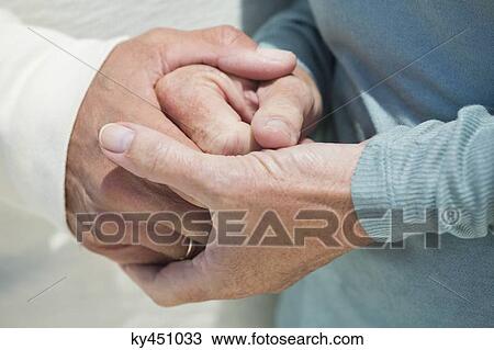 Close-up of a couple holding hands View Large Photo Image Stock Image - Close-up of a couple holding hands. Fotosearch