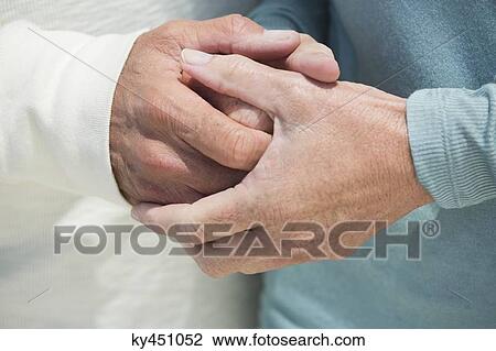 Close-up of a couple holding hands View Large Photo Image Stock Image - Close-up of a couple holding hands. Fotosearch