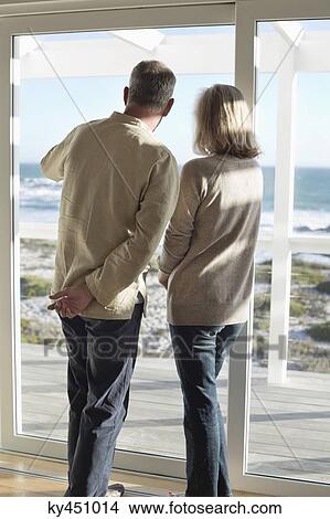 Picture - Couple looking through a window. Fotosearch