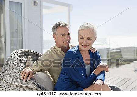 Stock Photo - Couple sitting in a wicker chair romancing. Fotosearch