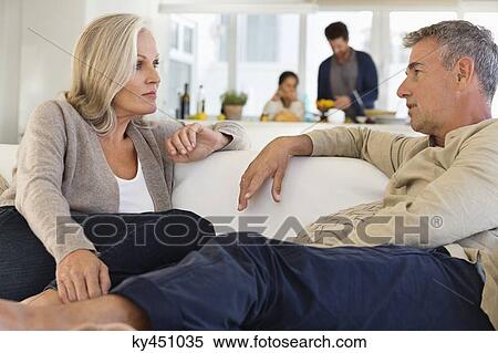Couple talking on a couch at home View Large Photo Image Stock Photography - Couple talking on a couch at home. Fotosearch