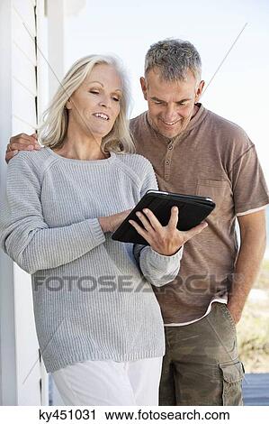 Couple using a digital tablet View Large Photo Image Stock Image - Couple using a digital tablet. Fotosearch
